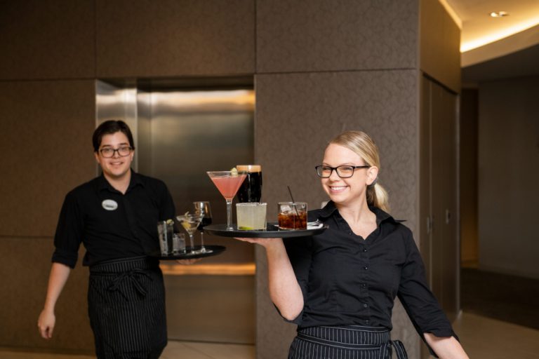 Team Members At The Clubhouse Bring Drinks to Customers